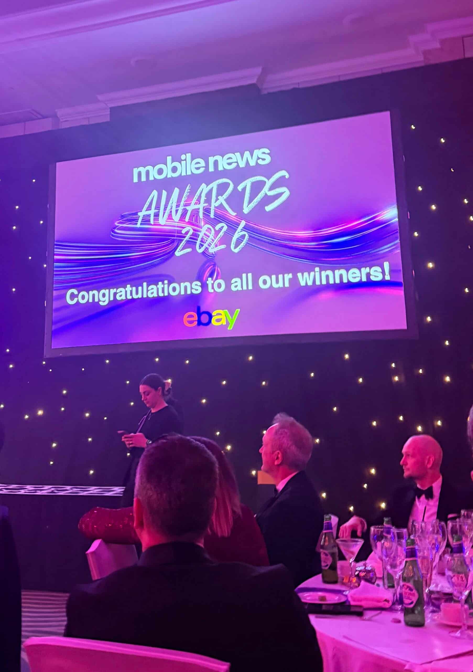 Mobile News Awards 2026 event with a large screen displaying winners.