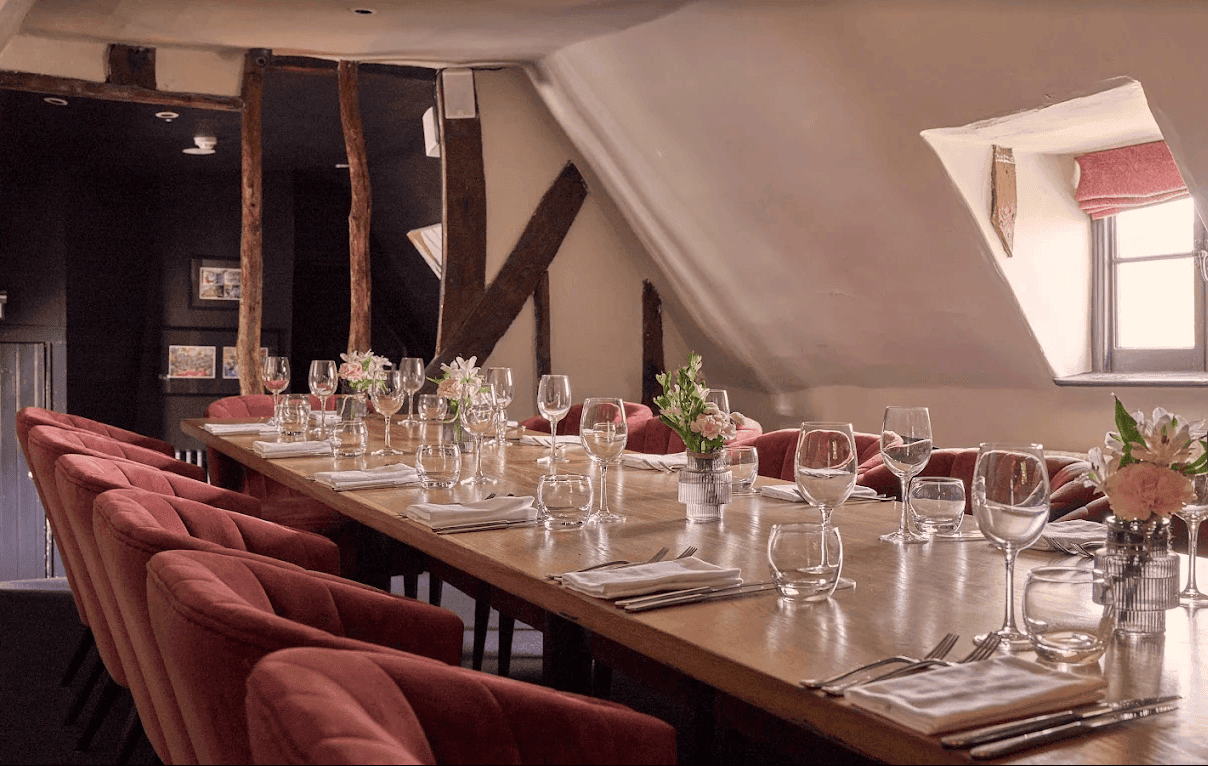 Elegant dining table set for a formal event in a cozy attic room.