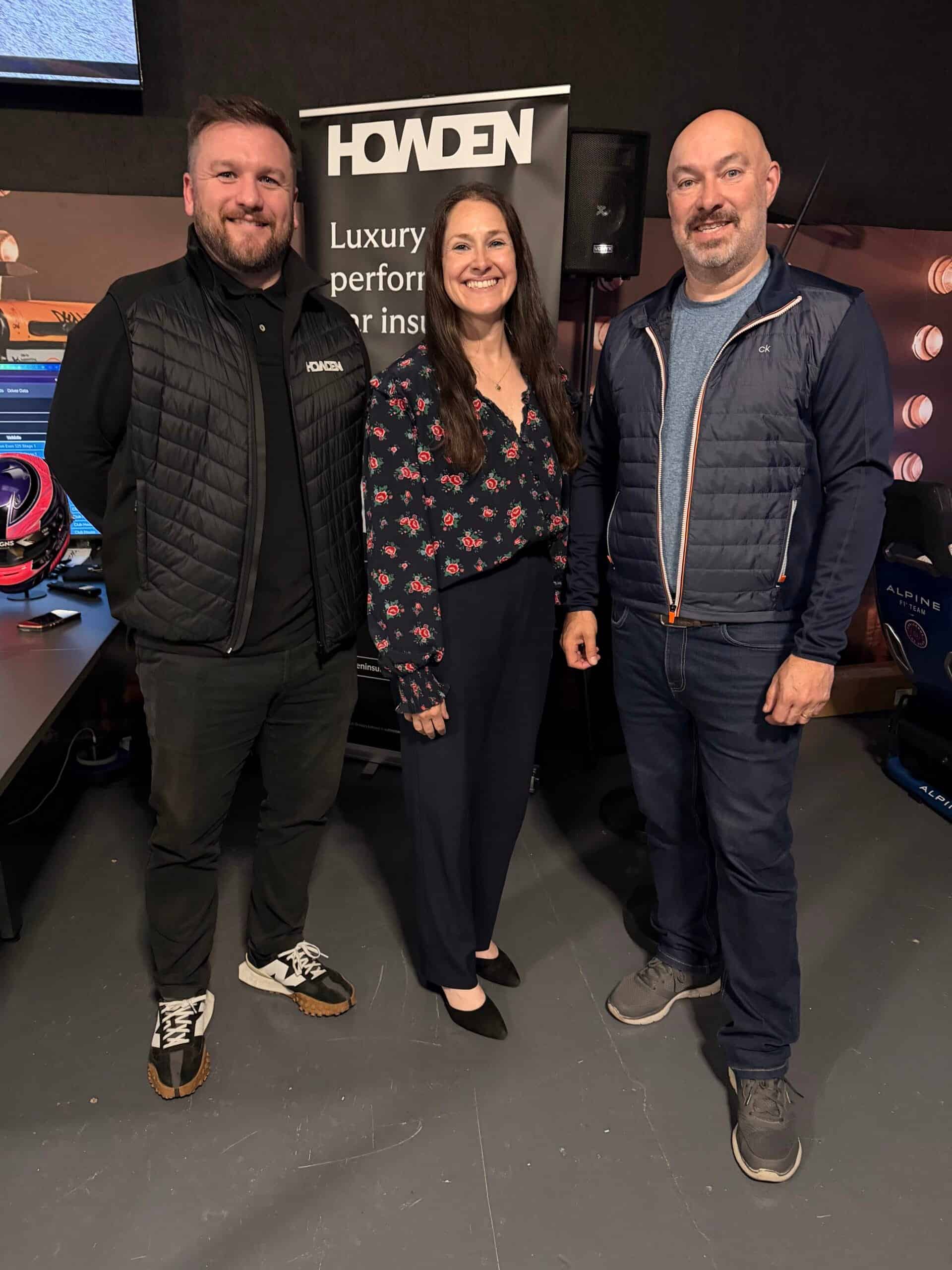 Three people at an event with Howden branding in the background.